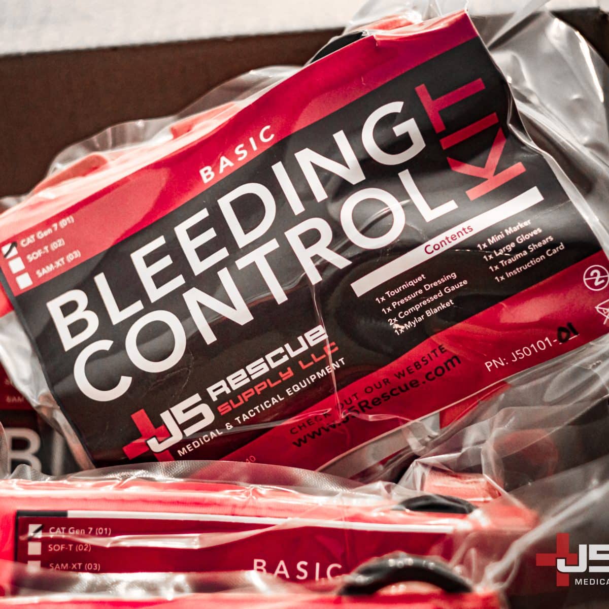 Close-up of JS Rescue Supply LLC's vacuum-sealed Bleeding Control Kits: clear packaging, detailed contents, prominent branding.